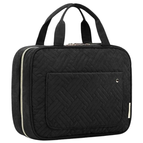 Black quilted travel toiletry bag with dual carry handles, zip-around closure, and a front slip pocket, designed for organizing cosmetics and travel essentials.